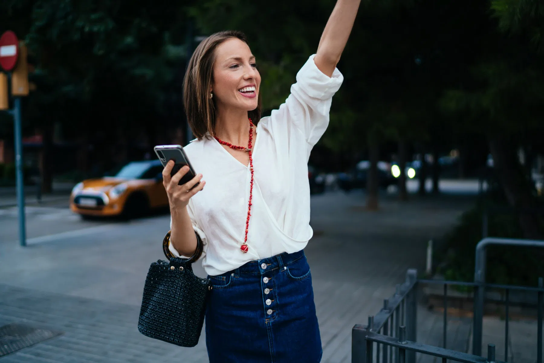 Passagère qui hèle un taxi avec son téléphone